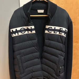 Moncler Cardigan navy 9B000 - Storlek L sitter som M. Fläckfri och i nyskick. Inte en skråma eller fläck. Passar dig mellan 1.80-1.90 lång. Pris kan diskuteras LITE. Slutsåld på de flesta hemsidor.