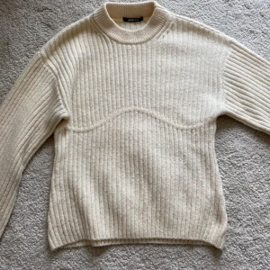 Beige ribbstickad tröja från Gina tricot - Säljer en beige ribbstickad tröja från gina tricot med rund halsringning. Tröjan har långa ärmar och är tillverkad i ett mjukt material.