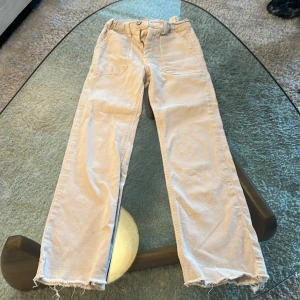 Beiga raka jeans från ZARA - Säljer ett par beiga raka jeans från ZARA med råa, fransiga benslut och klassiska fickor fram och bak. Byxorna har normal passform och är tillverkade i ett mjukt bomullsmaterial. Perfekta för en avslappnad stil.