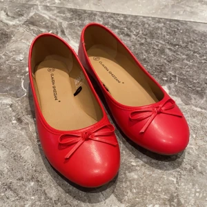 Röda ballerinaskor med rosett  - Säljer ett par klassiska röda ballerinaskor från Claudia Ghizzani. Helt nya! Skorna har rund tå och en söt rosett framtill. Perfekta för dig som vill ha en färgklick till outfiten. Jag har flera storlekar, inte bara 40. Säljer även ett par guldiga, och har även vita och svarta o flera storlekar. Hör av er vid intresse💛