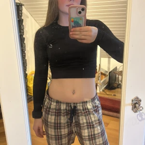 Svart långärmad träningströja  - Snygg svart träningströja med lång ärm. Tröjan har en tight passform och är tillverkad i ett stretchigt material, optimalt för all sorts träning.