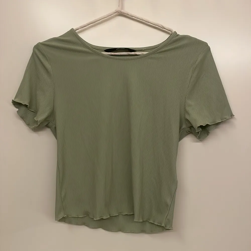 Snygg grön ribbad topp från Vero Moda med korta ärmar och en avslappnad passform. Perfekt för en stilren och bekväm look. Pris kan diskuteras . Yläosat.