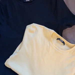 Svart och gul t-shirt från Bik Bok - Två stilrena t-shirts från Bik Bok i svart och gul färg. Perfekta för en avslappnad look. Båda t-shirts har en klassisk rund hals och korta ärmar. Passar bra till jeans eller shorts för en enkel och snygg outfit.
