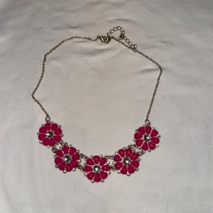 Blommigt halsband med rosa detaljer - Charmigt halsband med fem blommor i rosa och silver. Blommorna är jämnt fördelade längs kedjan och ger en färgglad touch till din outfit. Perfekt för att liva upp vilken look som helst!