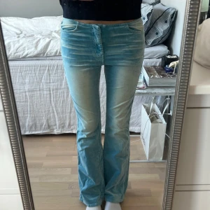 Ljusblå bootcut jeans - Supersnygga lågmidjade bootcut jeans i ett lite speciellt material som inte riktigt är som denim, visas lite tydligare på sista bilden.