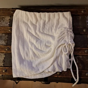 Vit kjol med dragsko från Gina Tricot - Säljer en snygg vit kjol från Gina Tricot med dragsko i midjan. Perfekt för en avslappnad sommarlook. Kjolen är i en mjuk och bekväm design.