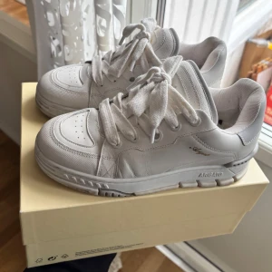 Vita sneakers från Axel Arigato - Snygga vita sneakers från Axel Arigato. Fint skick. Köpt för 3250kr. Skorna kommer i originalförpackning, kvitto & extra oanvända skosnören. Pris går att diskutera.