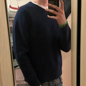 Mörkblå tröja från Uniqlo - Säljer en stilren mörkblå tröja från Uniqlo. Tröjan är långärmad och har en klassisk rund halsringning. Storlek xl men har blivit tvättad så den sitter som M