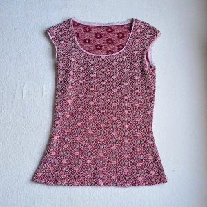 Röd blommig topp - Snygg röd ärmlös topp med ett blommigt mönster i vitt. Använd fåtal gånger superfint skick. Upskattad storlek S.  