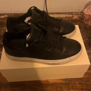Svarta sneakers från Axel Arigato - Snygga svarta sneakers från Axel Arigato.Använda men i bra skick.