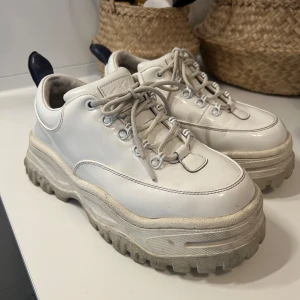 Eytys Angel - Säljer ett par vita sneakers från Eytys med chunky sula och snörning. Skorna har en stilren design med en robust gummisula och blank utsida. Kommer inte till användning längre. 500kr eller bud. Kan frakta men också mötas upp i Täby/Stockholm innerstad