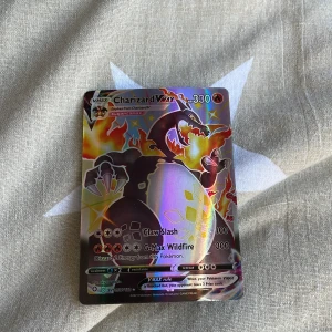 Charizard VMAX Pokémonkort - Säljer ett Charizard VMAX Pokémonkort med 330 HP. Kortet har attacker som Claw Slash och G-Max Wildfire. Det är en del av sv107/sv122 serien och har en holografisk yta som ger det en unik glans. Perfekt för samlare eller Pokémon-entusiaster! Obs hämtas i Uppsala säger adressen när någon är intresserad!