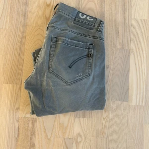 Gråa Dondup Jeans - Assnygga gråa Dondup George med slitningar. Storlek 30. 7/10 skick enda defekten är ett hål på ena knäet . Gå in och kolla profilen, massa snygga jeans!