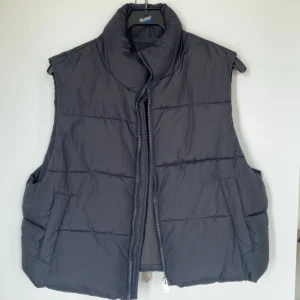 Svart dunväst  - Säljer en svart dunväst från lager 157 med dragkedja framtill. Västen har en hög krage, den har även fickor på sidorna och är perfekt för kyligare dagar som till vår och höst. Knappt använd! Är XL men passar även till M!