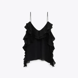 Svart ärmlös topp med volanger - Snygg svart ärmlös topp med tunna axelband och flera lager av volanger framtill. Perfekt för en elegant look. Använd 1 gång 🎊💘stl L men passar M