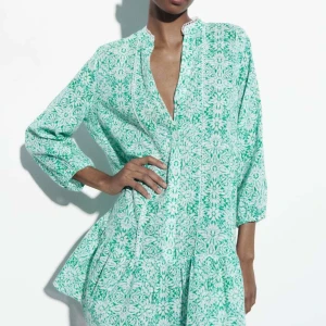 Somrig zaraklänning - Snygg grön klänning med blommigt mönster och trekvartsärmar. Perfekt till sommaren! Säljes då den inte kommer till användning längre, bra skick. 