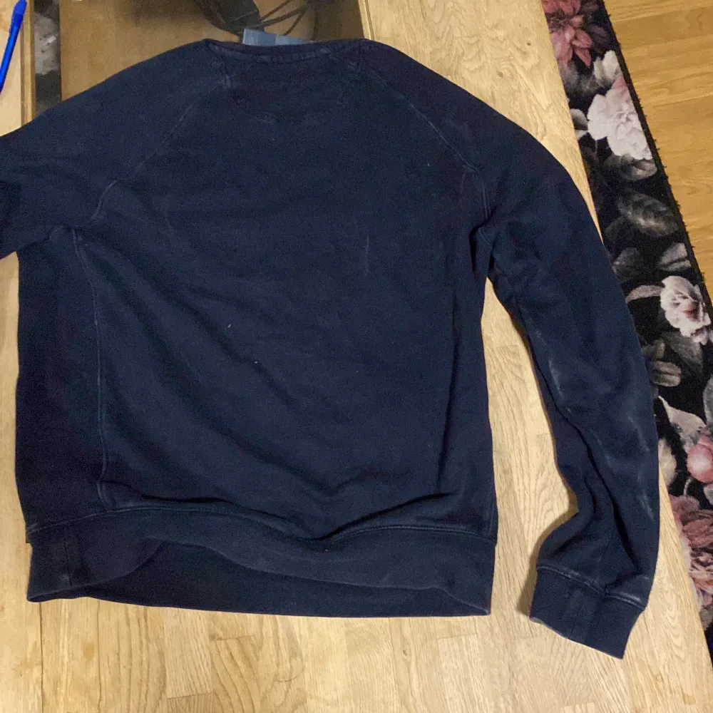 Säljer en mörkblå tröja från Henri Lloyd med ett broderat märke på bröstet. Tröjan har långa ärmar och ribbade muddar vid ärmslut och nederkant. Perfekt för en avslappnad stil.. Neuletakit & Villapaidat.