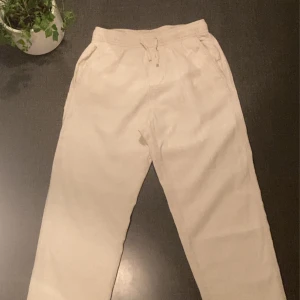 Linnebyxor från H&M - Säljer ett par bekväma linnebyxor från H&M. De har en elastisk midja med snörning och en bakficka. Perfekta för en avslappnad stil. De har två små prickar vid vänster ficka som man täcker med en tröja.