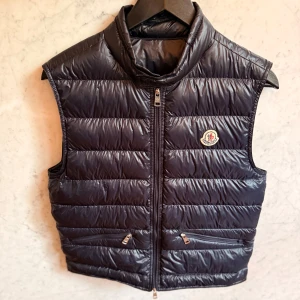 Night Blue dunväst från Moncler - Moncler Gui Gilet i mycket bra skick.  Köpt ny 2023 och inte använd sedan hösten 2024.