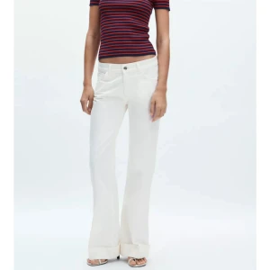 Vita vida linnebyxor med uppvik - Säljer dessa helt nya slutsålda Zara jeans k storlek 36 med lapp kvar! Snygga vita jeans med flare ben och uppvik nertill. Byxorna har låg midja och klassisk femficksdesign. Perfekta för en fräsch och clean look, matcha med crop top eller skjorta för en chill vibe.