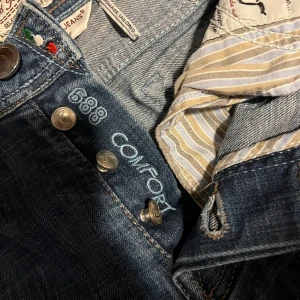 Jacob Cohen - Kommer typ behålla dessa jeans för de är så feta men men… Behöver pengarna😅 Dessa jeans är i modell 688 vilket är en personlig favorit, Sitter perfekt runt benen liksom passar allt. Modellen är cirka 186cm 70kg. 4/5 skick, det är en liten slitning på baksidan av jeansen men osäker om de är design. Tveka inte på att höra av dig, svarar oftast inom 15 min. Byten kan hända! 