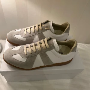 Vita grå maison margiela  - Snygga maisons i vitt och ljusgrått med ovandel i mocka och skinn. Köptes på Maison margielas hemsida. |väldigt bra skick-: 9/10|. Storlek 42. |Nypris-:5890| Mitt pris-: 3190 Säljs billigt då ja fick dom i present men tyvärr var fel storlek. Bara att Dma vid funderingar🤙