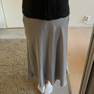 Silver/Grå långkjol  - Supersnygg grå/silvrig satin långkjol! Passar till vardag eller festligare tillställningar! Resor i midjan och väldigt bekväm♥️