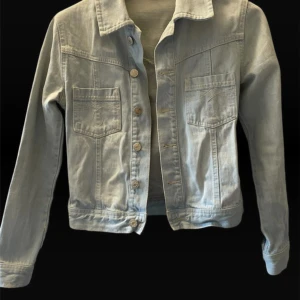 Ljusblå jeansjacka - Snygg ljusblå jeansjacka från H&M med klassisk krage, två bröstfickor med broderade detaljer och knäppning framtill. Jackan har raka ärmar och en clean, tidlös look som passar perfekt till din vardagsstil. 💞
