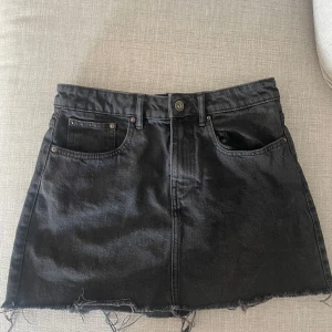 Svart jeanskjol med fransig kant - Svart kort jeanskjol från zara, storlek M med lite slitning längs ner 