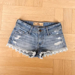 Supersöta hollistershorts med spets - Lågmidjade, i en ljusblå färg och med en unik såetsdetalj nere. OBS! Kolla mått innan du köper, syns i bilderna🌺 Fråga om du undrar något annat❤️