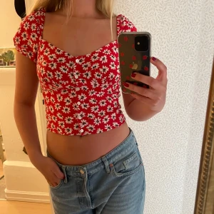  Blommig croppad topp  - Säljer en söt och somrig topp/blus som sitter croppat och har puffärmar. Toppen är från Bershka och är i storlek M. 
