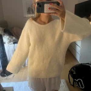 Vit stickad tröja med rosett i ryggen - Superfin vit stickad tröja med breda ärmar och öppen rygg som knyts med en stor rosett. Tröjan har ribbad struktur och känns både mysig och trendig. Köpte den för 500 kr men kommer tyvärr inte till andvändning🩷