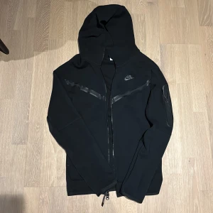 Svart Nike tech hoodie XS/S - Säljer vidare min Svarta Nike tech i storlek XS men kan också passa som S. Mycket bra skick, originalpris ligger på cirka 1299 kr 