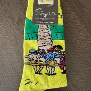 Gula Oddlysocks strumpor med konstmotiv - Unika gula strumpor från Oddlysocks med konstnärligt motiv inspirerat av Carl Larsson. Frukost under stora björken. 