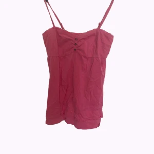 Babydoll topp från edc! - Supersöt varm rosa linnetopp från edc by esprit med justerbara axelband, dekorativa knappar framtill och spetsdetaljer längs kanterna. Toppen är gjord av 100%  bomull och har en babydoll passform!