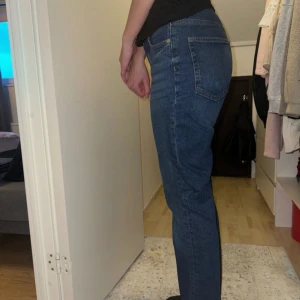 Vintage straight jeans från H&M - Säljer ett par klassiska blå jeans från H&M i modellen Vintage Straight. De är högmidjade med raka ben och tillverkade i denim.