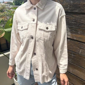 Zara manchester jacka - Oversized beige manchesterjacka från Zara med klassisk krage, stora bröstfickor med knappar och svarta knappar framtill. Jackan har långa ärmar och en rak, lite loose passform. Perfekt för dig som gillar en chill och trendig look. Använd bara en, två gånger. Storlek S. Oversize.