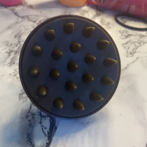 Svart silikon hårbottenborste - En brun hårbottenborste i mjuk silikon med rund form och greppvänligt handtag. Borsten har flexibla piggar som masserar hårbotten och hjälper till att rengöra på djupet. Perfekt för att boosta blodcirkulationen när du tvättar håret. Den är aldrig andvänd .