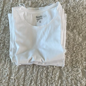 Vit t-shirt Basic You i bomull - 4 stycken Klassisk vit t-shirts från Basic You i ekologisk bomull. Enkel och stilren design med rund halsringning och korta ärmar. Perfekt att matcha med jeans eller shorts för en clean look.