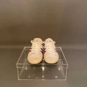 Beige sneakers från Moncler mocka - 40,5 passar 41. Snygga beige sneakers från Moncler i mocka med klassiska ränder i rött, vitt och blått på sidan. Skorna har rund tå, platt sula och snörning framtill. Perfekta för dig som gillar stilrena och sportiga vibes med en touch av lyx.