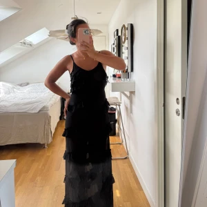 Långklänning - Super fin svart långklänning med slits och lite lägre skurning i ryggen. Med volanger. Vet inte vart den är köpt ifrån men den har aldrig använts utan bara dammats i garderoben 🖤.