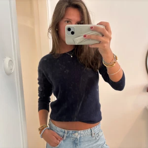 Mörkblå kashmirtröja från From Future - Mysig mörkblå kashmirtröja från From Future med rund halsringning och lång ärm. Tröjan har en enkel, klassisk design och är lite croppad i modellen. 