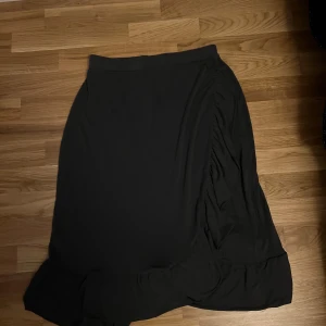 Grå långkjol med volangdetalj - En mörkgrå långkjol i storlek S
