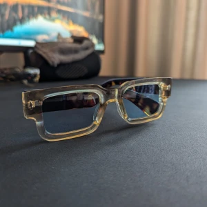 Snygga modesolbrillor - Snygga solglasögon med rektangulära bågar i transparent plast med inslag av brunt och svarta glas. Skalmarna har en mörkbrun sköldpaddsmönstrad look som ger extra edge. Perfekta för dig som vill sticka ut med en unik stil.