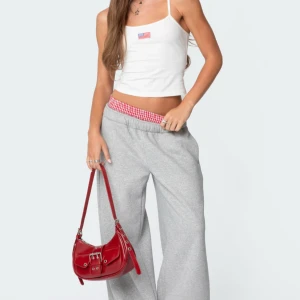 Grå sweatpants med gingham-detalj Edikted - Grå mjukisbyxor från Edikted med bred, lös passform och elastisk midja. Byxorna har en unik rödvitrutig gingham-detalj i midjan som sticker upp som en boxerkant. Såå sköna!!💕 helt nya och oanvända🙌🏻