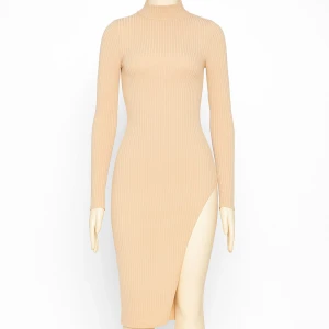 Beige ribbad långklänning Boohoo - Ribbad beige långklänning från Boohoo med lång ärm, hög krage och slits på sidan. Klänningen har en slim passform och är tillverkad i ett mjukt stretchigt material som sitter snyggt på kroppen.