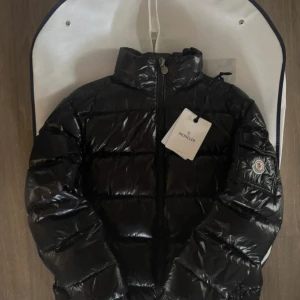 Svart Monclerjacka - Jacka från moncler, inga defekter har kvar påsen den kom i och lappen, det enda är att loggan har blivit lite sliten på kedjan (bild 5). Storlek 2 motsvarande M, Använd 1 vinter.