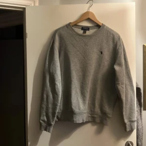 Grå sweatshirt från Polo Ralph Lauren - Säljer en klassisk grå sweatshirt från Polo Ralph Lauren med den broderade loggan på bröstet. Storlek Xl i barn men passar som S i herr storlek. Säljer den eftersom de har blivit för liten och är i mycket fint skick.