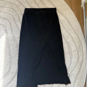 Svart kjol - En svart ribbad långkjol med slits. 