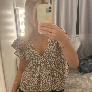 Blommig volang tröja - Jätte söt blommig volangtröj, inte kommit till användning och därför säljer jag den! Tröjan är i bra skick, förekommer inga defekter.